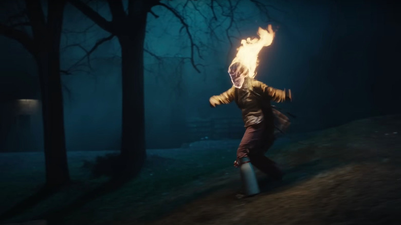 Sarah Levy as Aunt Ida flailing around with her head on fire in a scene from The Monkey