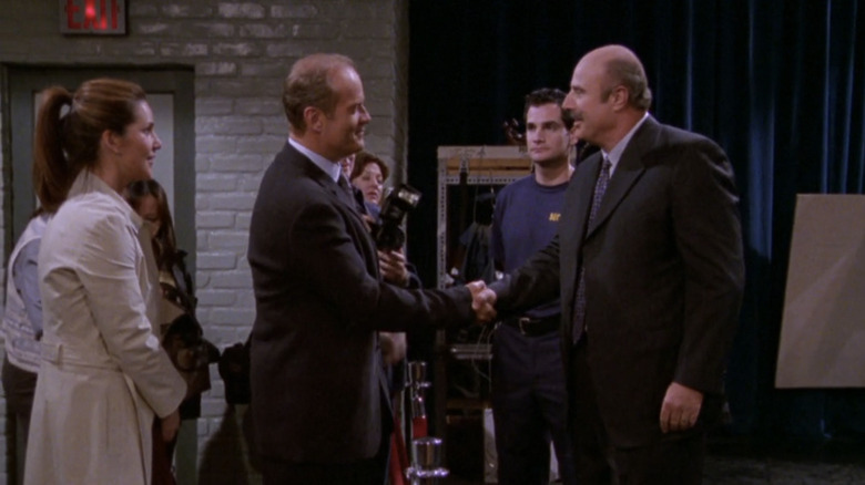 Frasier shakes hands with Dr. Phil in a TV studio