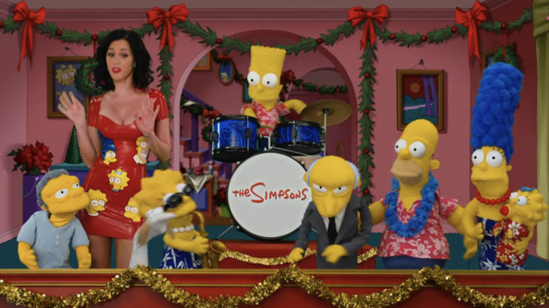 Katy Perry stands next to puppets of the Simpsons family in their living room in The Simpsons