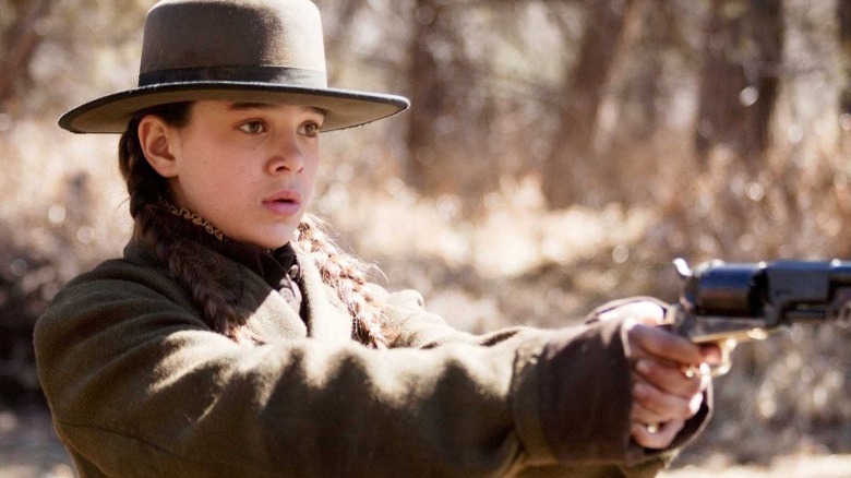 Hailee Steinfeld holds a pistol in True Grit