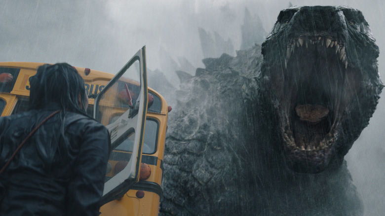 Godzilla roaring at a woman near a school bus on Monarch: Legacy of Monsters