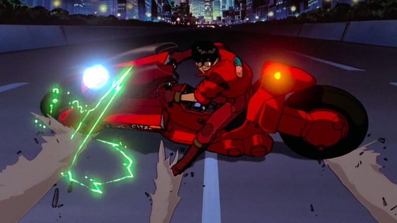 Kaneda power-sliding a motorcycle