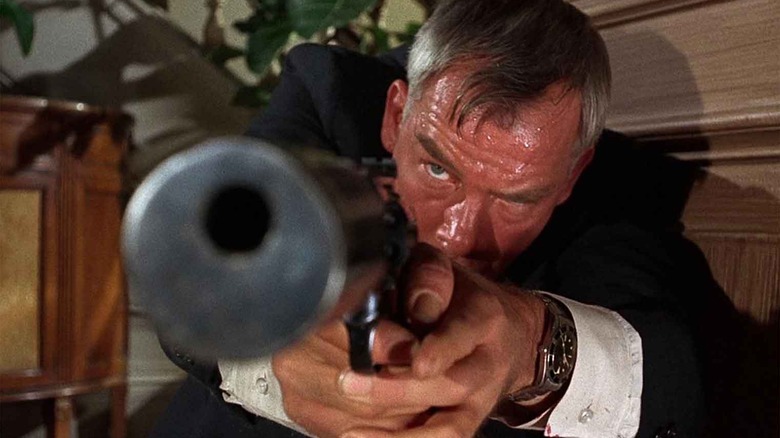 Lee Marvin aiming a silenced pistol