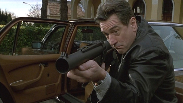 Robert De Niro stepping out of his car to fire a grenade launcher