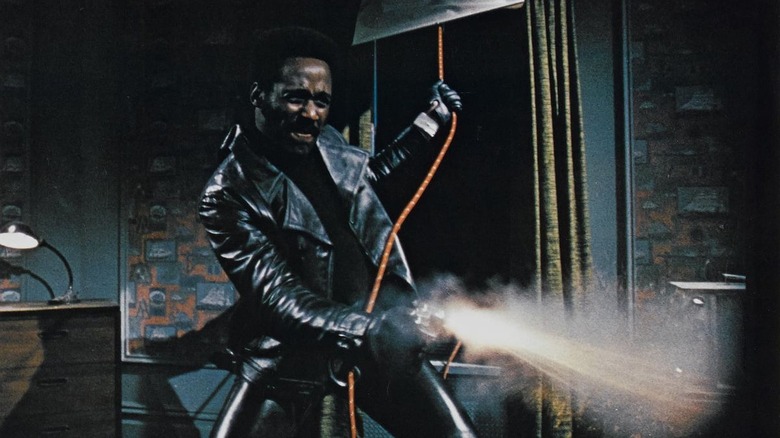 Richard Roundtree swinging through a window, shooting