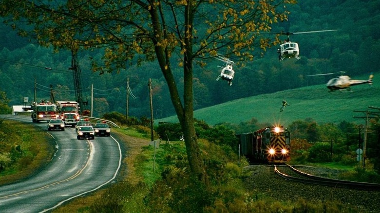 Emergency vehicles chase along side a runaway train as helicopters circle overhead