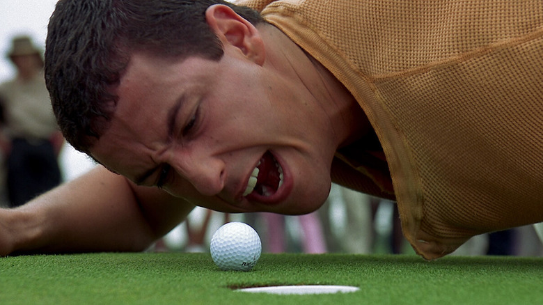 Happy Gilmore shouting at a golf ball next to the hole