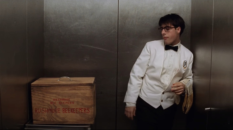 Max dressed as waiter in elevator