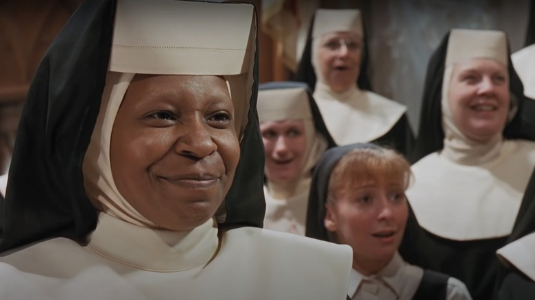 Whoopi Goldberg smiling in front of choir