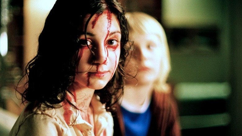 Young vampire covered in blood in Let the Right One In