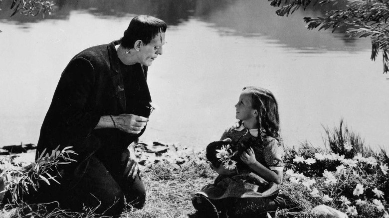 Frankenstein's monster picks flowers with a young girl
