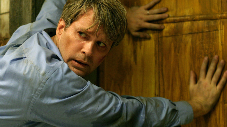 Cary Elwes reaches for door in Saw