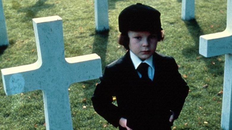 Damien stands in graveyard in The Omen