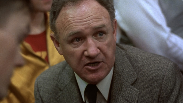 Treinador Norman Dale dando uma conversa em equipe em Hoosiers