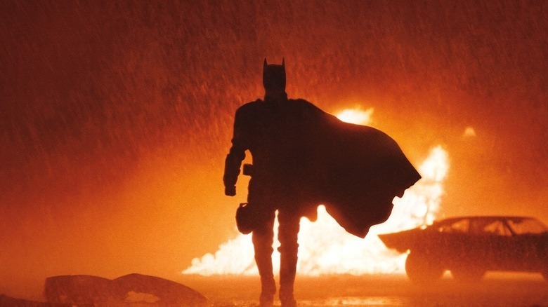 Batman, shrouded by flames, approaches his target.