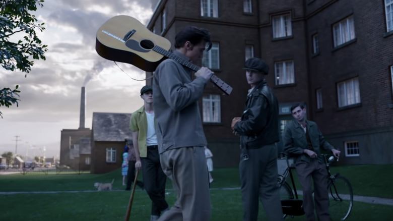 Austin Butler holds guitar with cast of "Elvis"