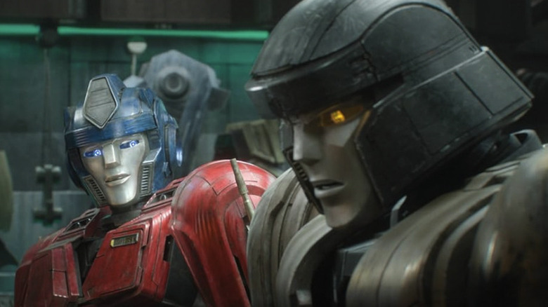 D-16 (Megatron) looking distraught while Orion Pax (Optimus Prime) sits next to him in Transformers One