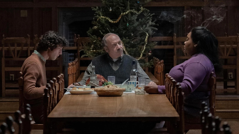 Angus, Paul, and Mary having dinner in front of a Christmas tree in The Holdovers