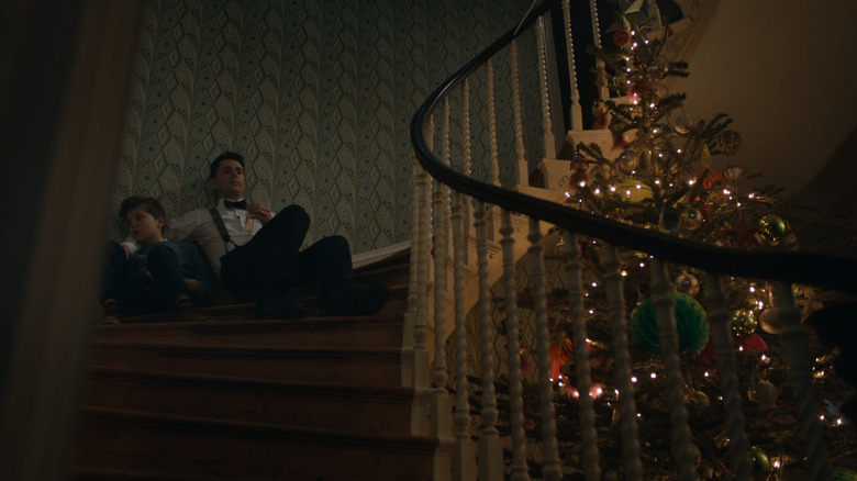 Art and Simon sit on the stairs near a Christmas tree in Silent Night