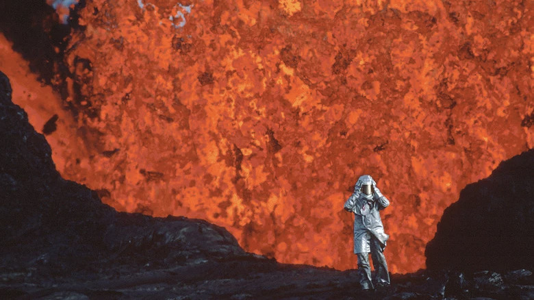 Krafft standing in front of a wall of lava in Fire of Love