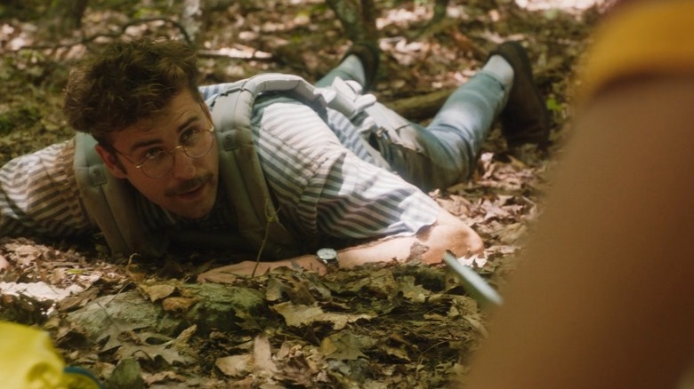 John Reynolds laying on forest floor leaves