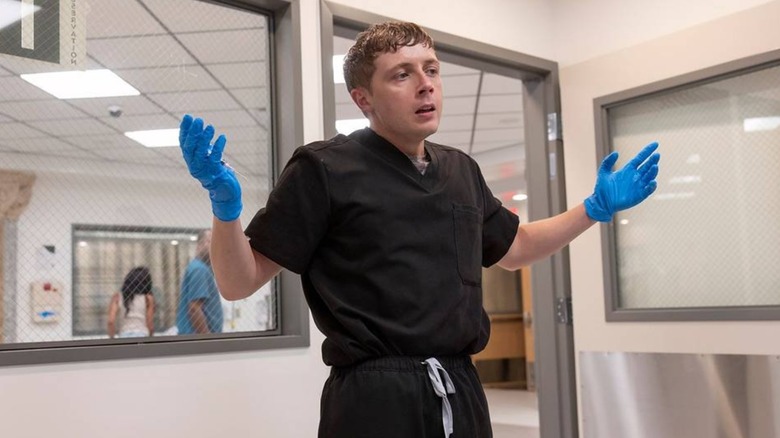 Gerran Howell's Dennis Whitaker holds his gloved hands up in surprise in The Pitt