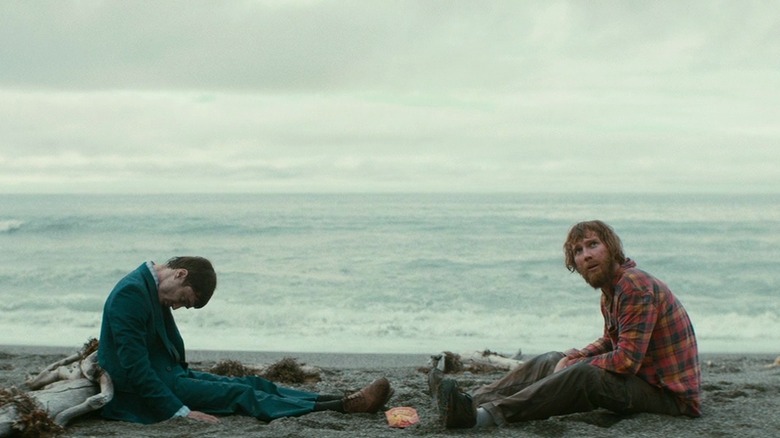 Paul Dano and Daniel Radcliffe sitting on beach
