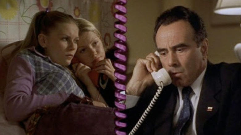 Betsy de Kirsten Dunst y Arlene de Michelle Williams hablando por teléfono con Richard Nixon de Dan Gifts separados por un cable telefónico rosa en Dick