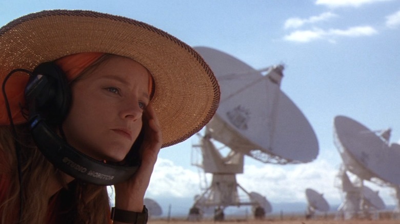 Jodie Foster wearing headphones around satellites