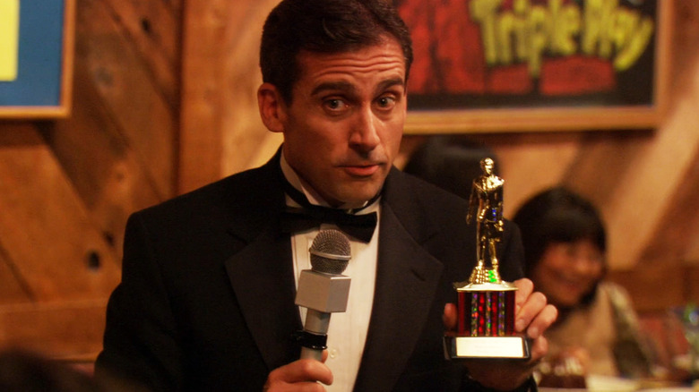 Steve Carrell's Michael Scott holds up a Dundie award in The Office