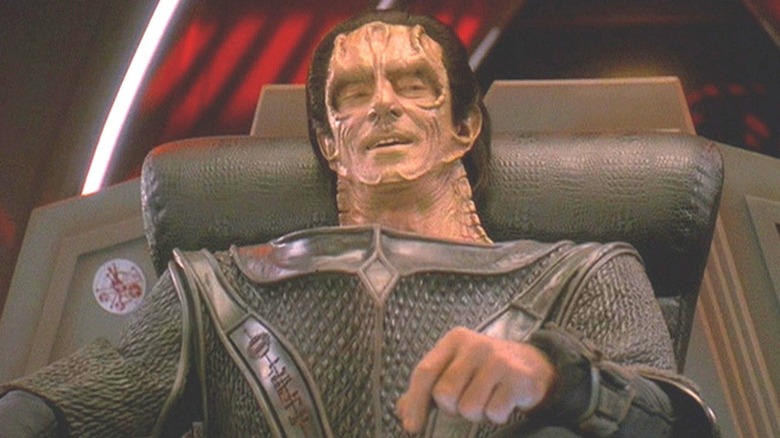 Dukat sits triumphantly in a chair in Star Trek: Deep Space Nine