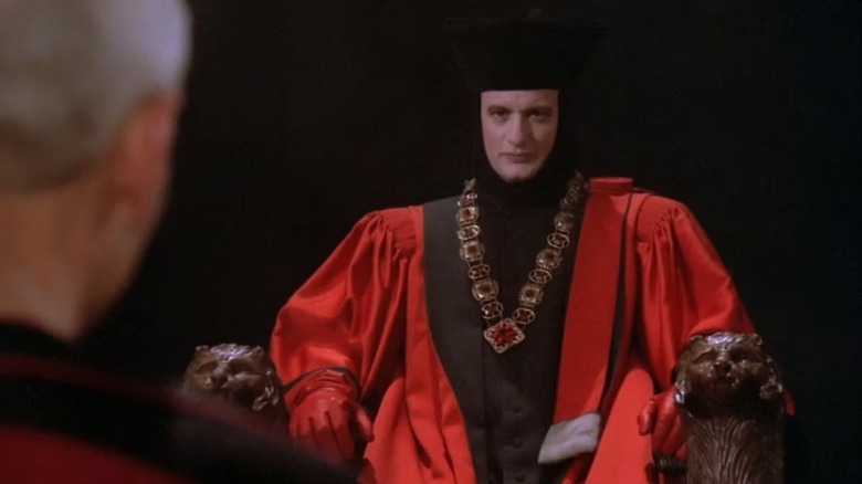 Q faces Picard sitting in a judge's chair in Star Trek: The Next Generation