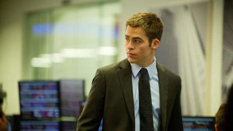 Jack Ryan in a suit looking over his shoulder with computers in the background in Jack Ryan: Shadow Recruit