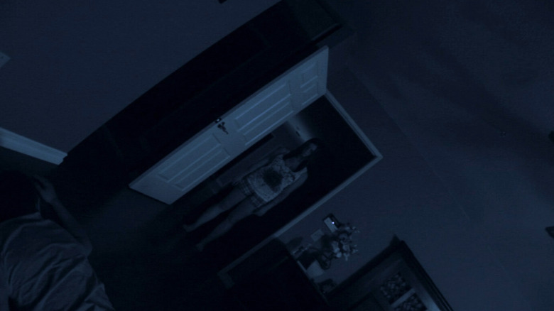 A bloody Katie stands in the doorway looking at the camera in Paranormal Activity