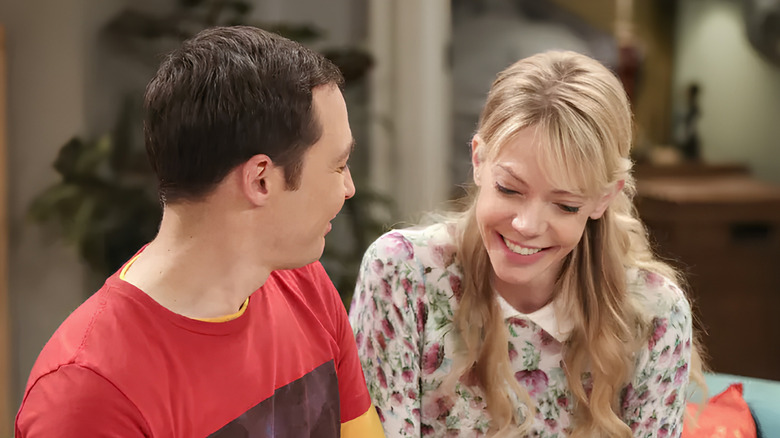 Ramona looking down and smiling with Sheldon on his couch in The Big Bang Theory