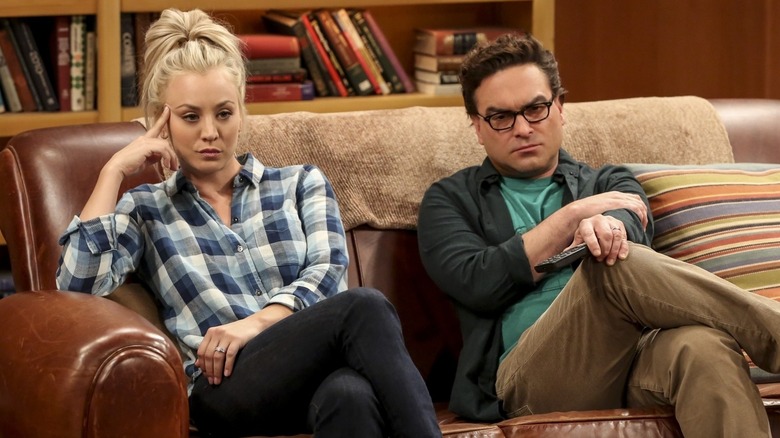 Leonard and Penny on the couch looking annoyed on The Big Bang Theory