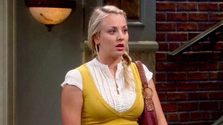 Penny looking shocked in her Cheesecake Factory uniform on The Big Bang Theory