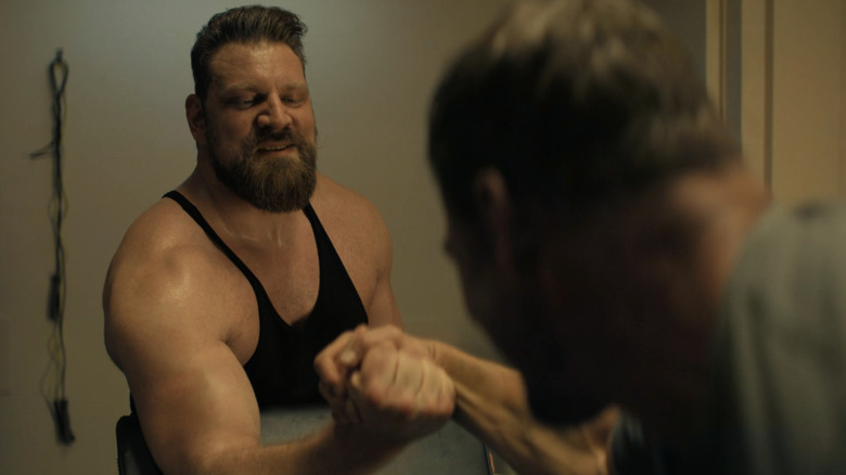 Olivier Richters' Paulie arm wrestles with Alan Ritchson's Jack Reacher in Reacher