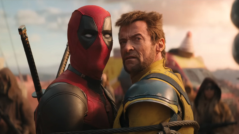 Deadpool and Logan look off into the distance as they stand tied together in a post apocalyptic wasteland in Deadpool & Wolverine