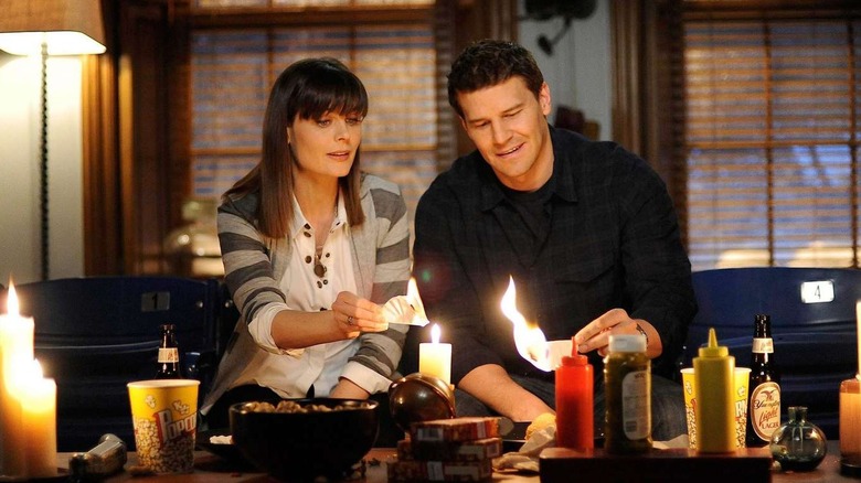 Brennan and Booth lighting candles on Bones