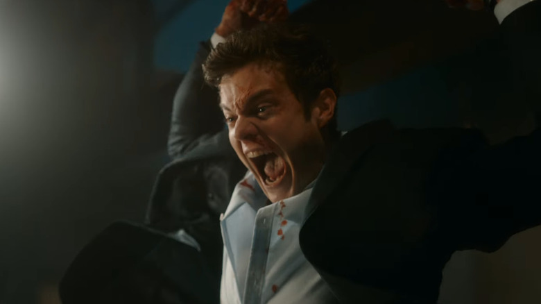 Jack Quaid as Nate jumping through the air to fight a guy in Novacaine