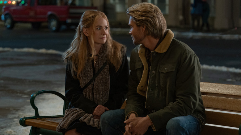 Ashley and Luke sitting on a bench in The Merry Gentlemen (2024)