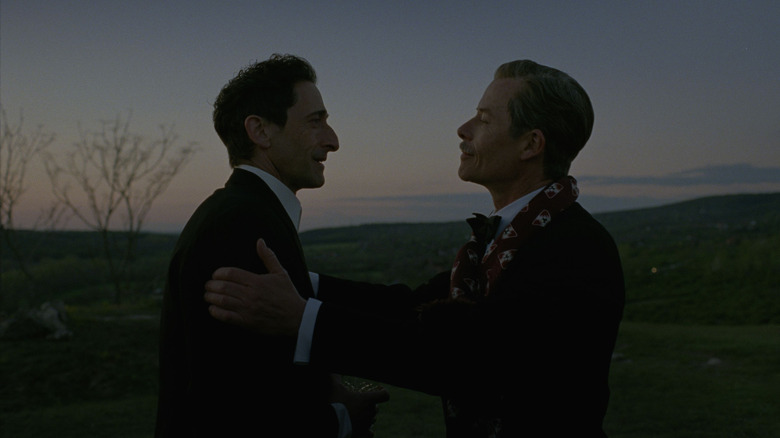 Harrison Lee Van Buren, Sr. (Guy Pearce) holds László Tóth (Adrien Brody) by the shoulders in The Brutalist