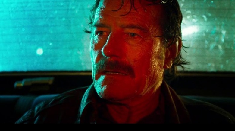 Robert Mazur, de Bryan Cranston, parecendo nervoso na traseira de um carro à noite em The Infiltrators