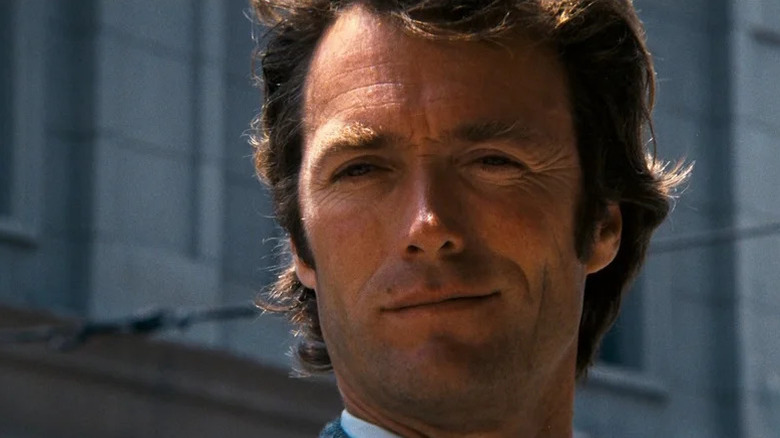 Harry Kalahan Clint Eastwood looks away against the background of buildings in the dirty mountain