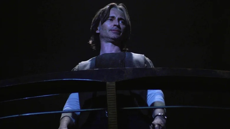 Nicholas Rush dari Robert Carlyle melihat ke bawah dari balkon di Stargate Universe