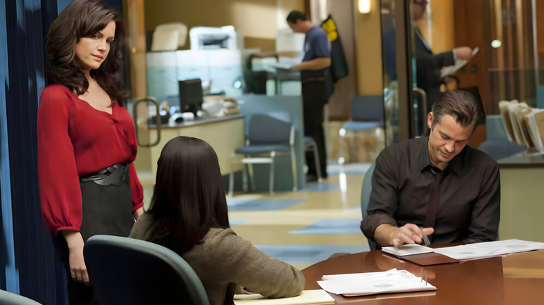 Karen Goodall standing next to a seated Raylan Givens on Justified