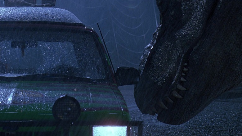 A T-rex nudging one of the Jurassic Park touring vehicles