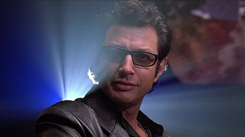 Dr. Ian Malcolm dressed in black and backlit in Jurassic Park