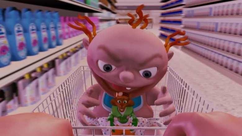 A baby in a shopping cart holds its hands around a tiny animal toy in Foodfight!